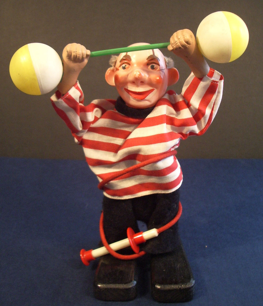 Arthur Schönau Sonneberg, A.S.S., fertigte anfänglich auch Figuren mit Uhrwerk. Als es aber immer schwieriger wurde, Werke zu bekommen, stellte er um auf Figuren, bewegt durch Bowdenzug. Seine Clowns, obwohl immer der gleichen Mechanik versehen, sind sehr vielseitig in ihren Bewegungen.